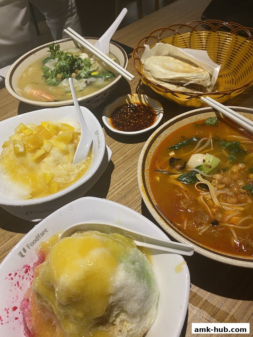 A table laden with various delicious Asian dishes, including noodle soups and shaved ice desserts.