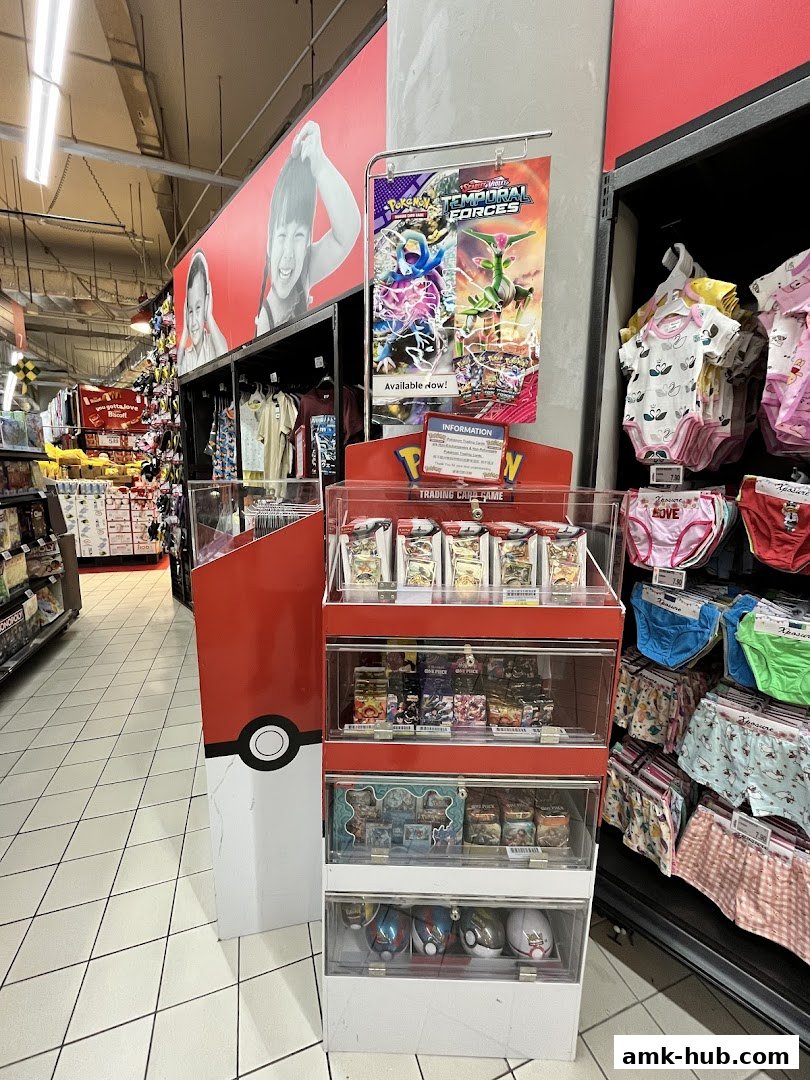 A display of Pokemon trading cards and children's clothing in a retail store.
