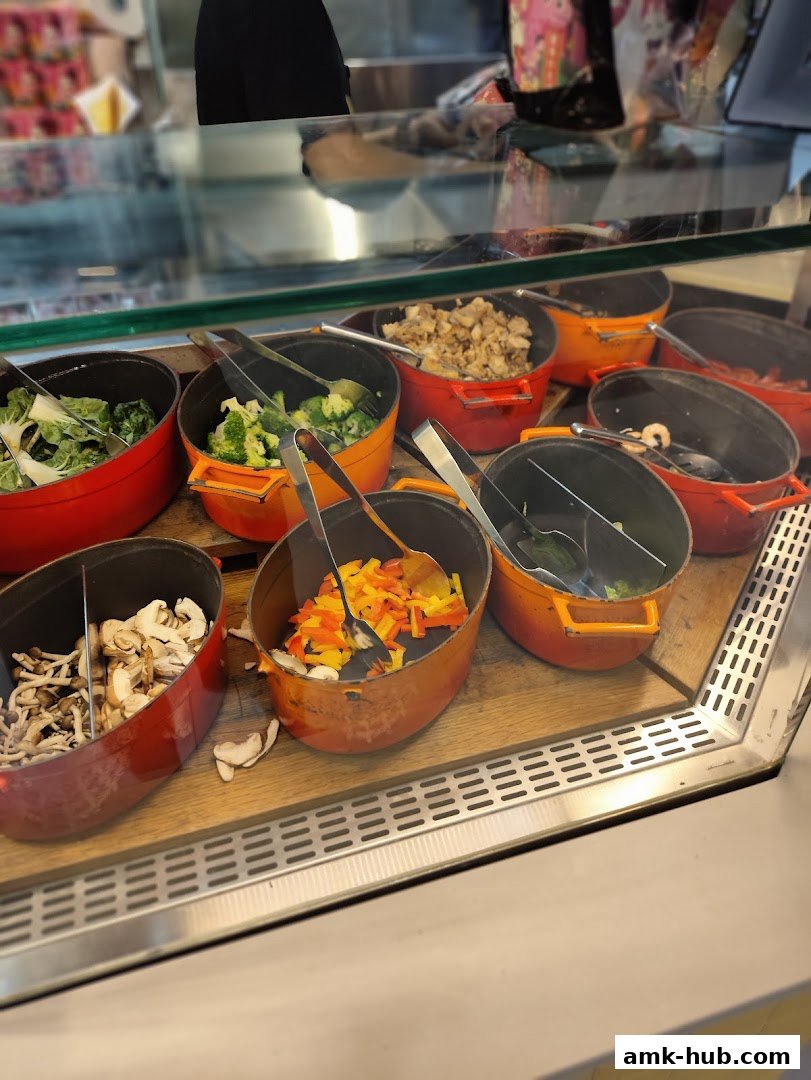A display of various fresh ingredients in pots, ready for cooking.