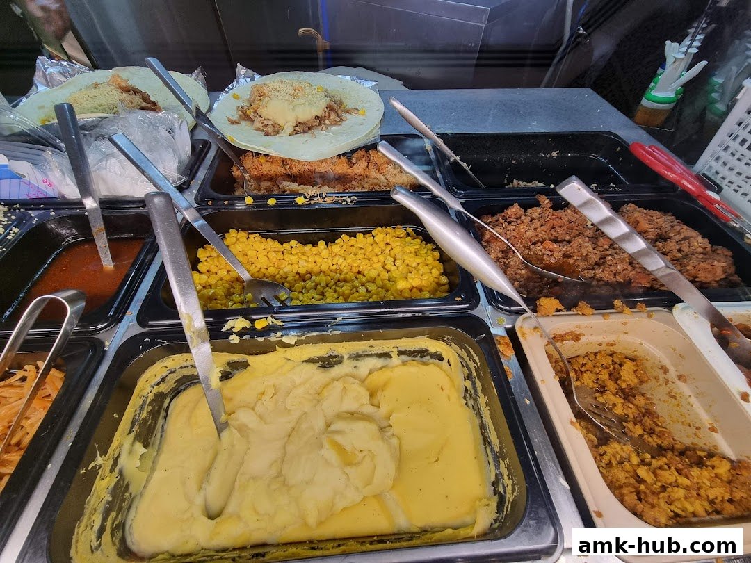 A display of various food ingredients, including mashed potatoes, corn, and meat fillings, ready for assembly.