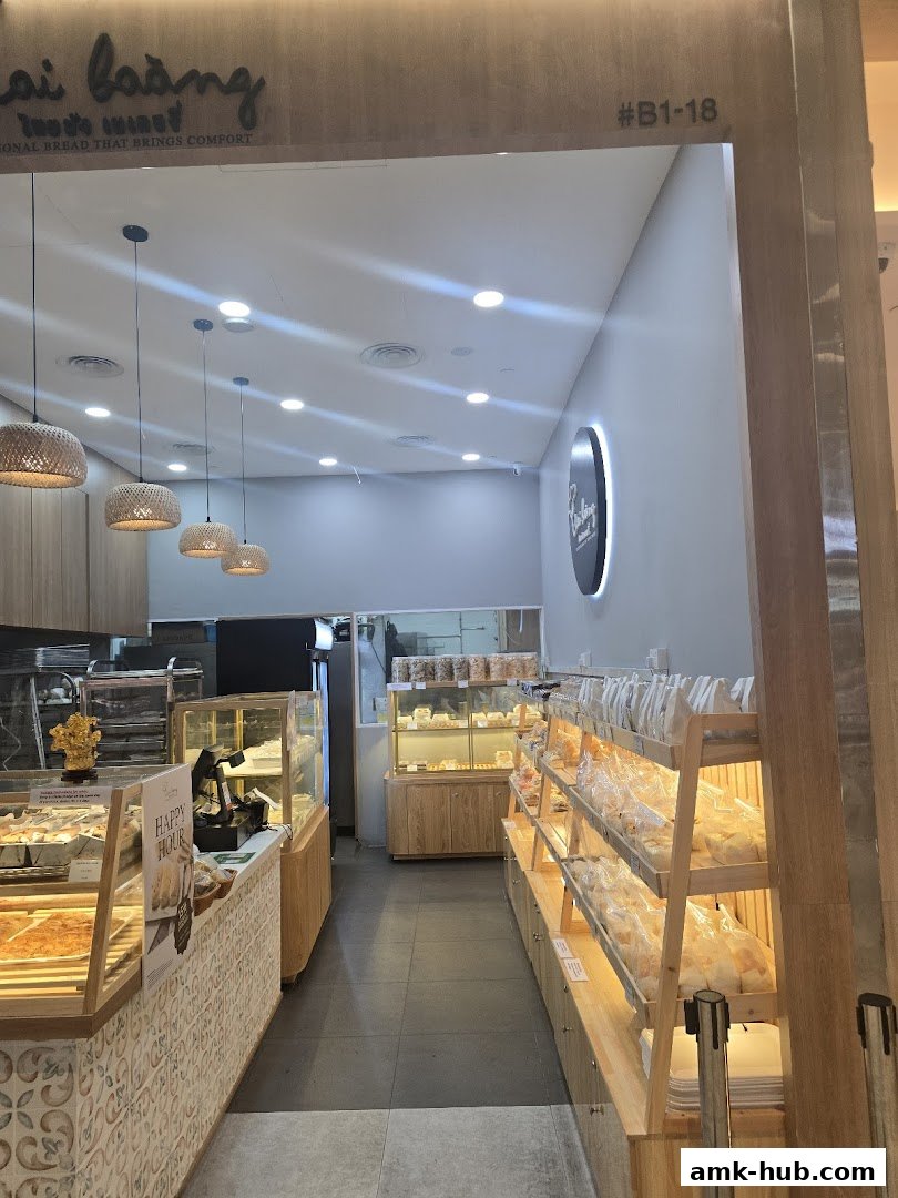 Interior view of a bakery with display shelves filled with bread and pastries.