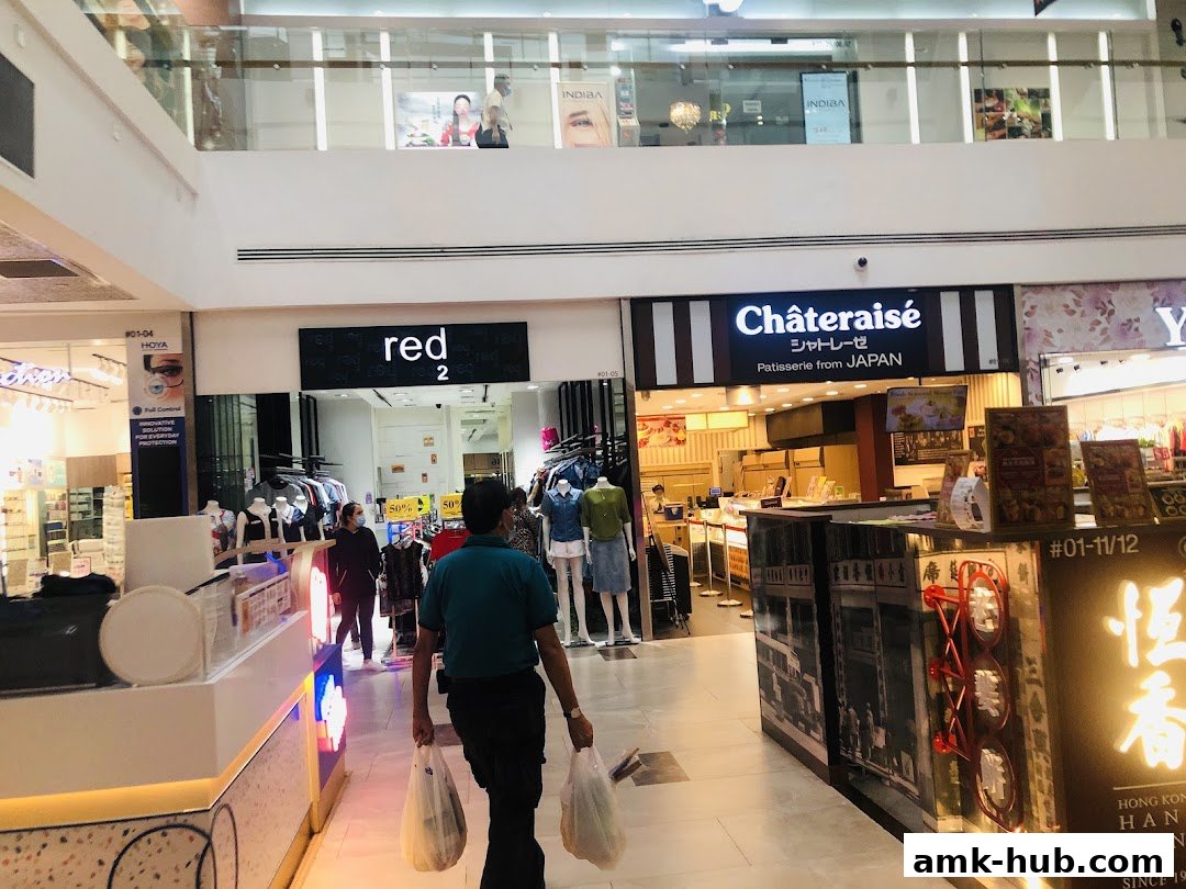 A shopping mall corridor with various shops, including Red 2 and Châteraisé.