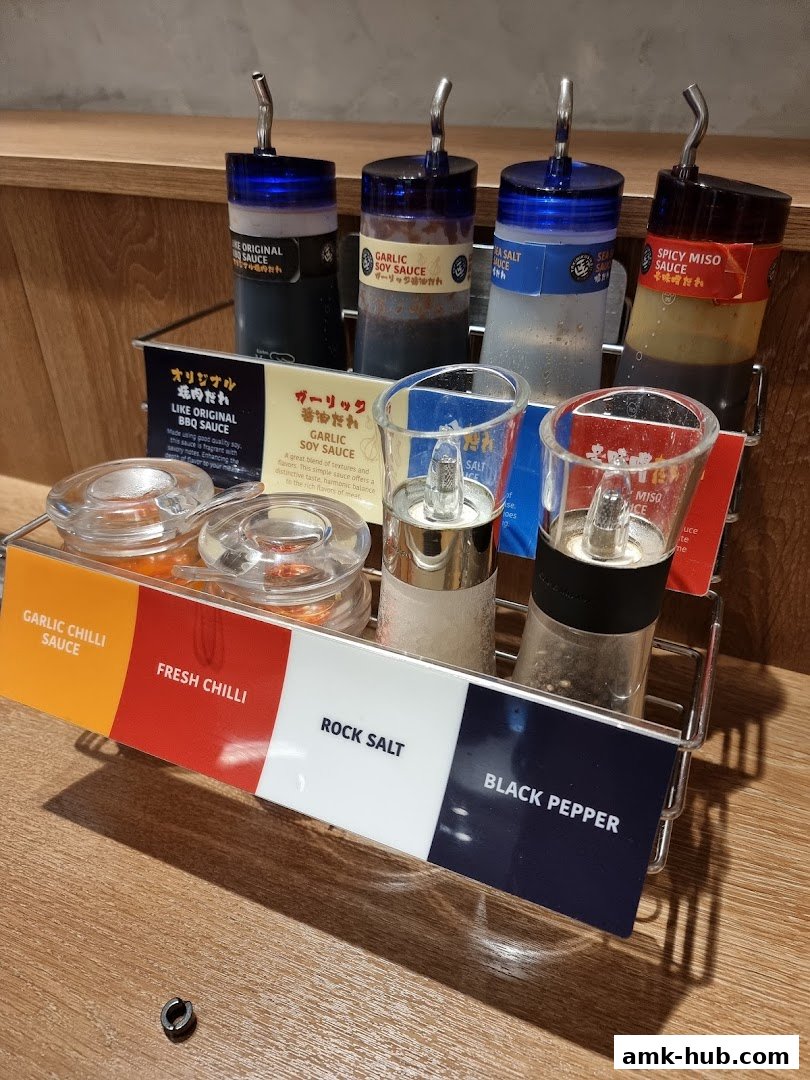Condiments and sauces are displayed on a wooden table at Yakiniku Like.