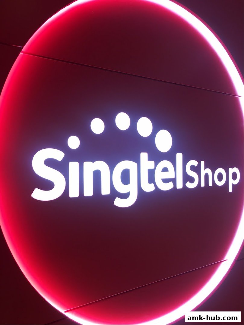 A close-up of the illuminated Singtel Shop logo with a red neon glow.