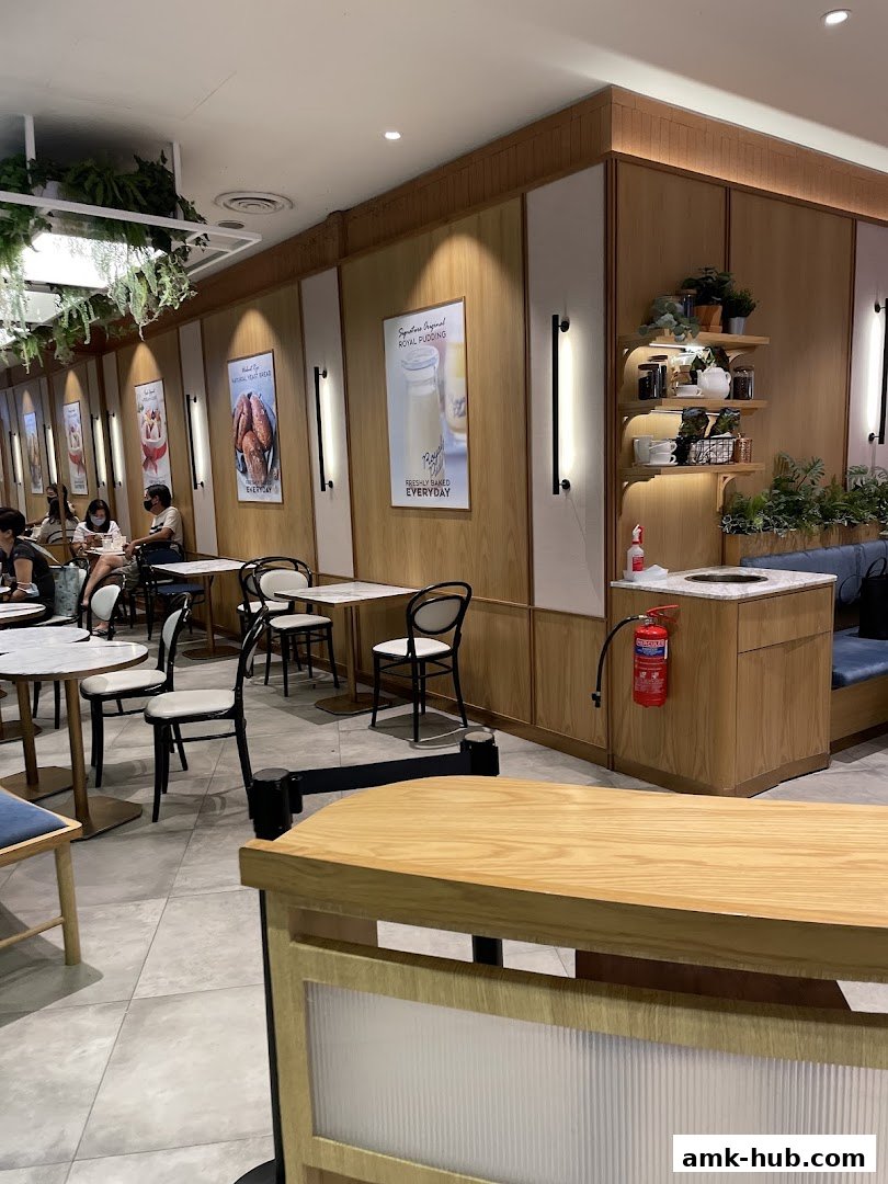 Interior view of Paris Baguette AMK Hub with seating, decor, and promotional posters.