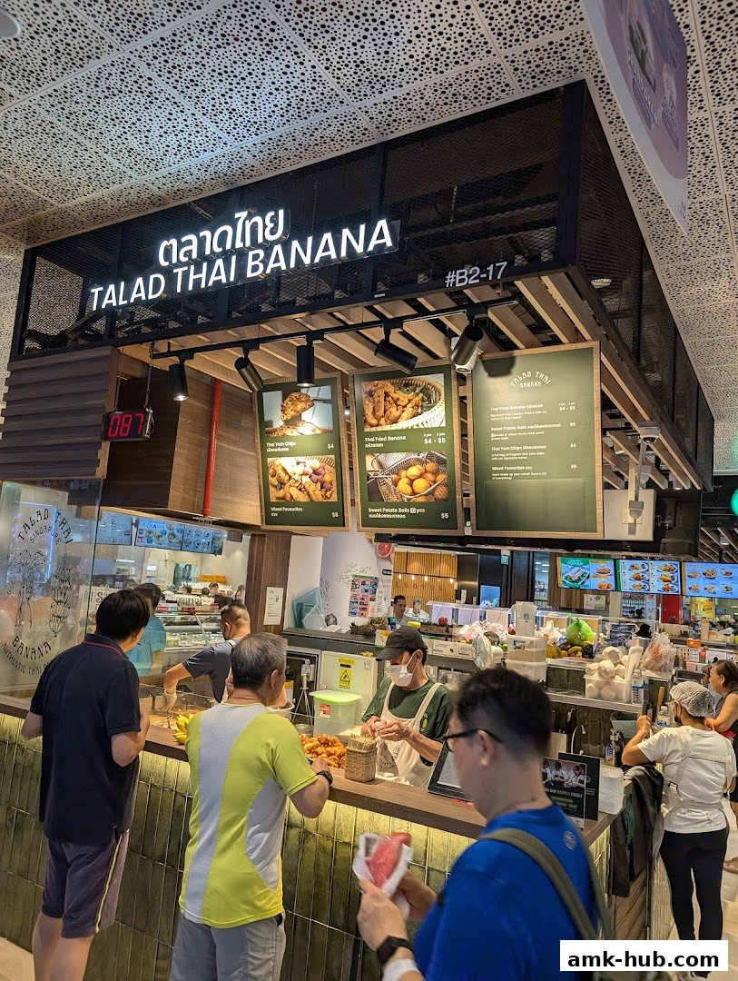 Customers ordering at a food stall with a prominent sign for Talad Thai Banana.