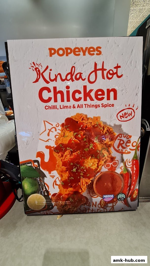 A promotional sign for Popeyes' Kinda Hot Chicken with chili, lime, and spice.