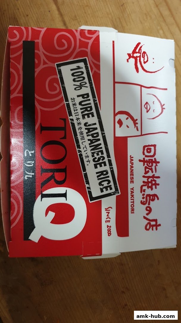 A closed TORI-Q takeout box featuring Japanese text and a sticker about pure Japanese rice.