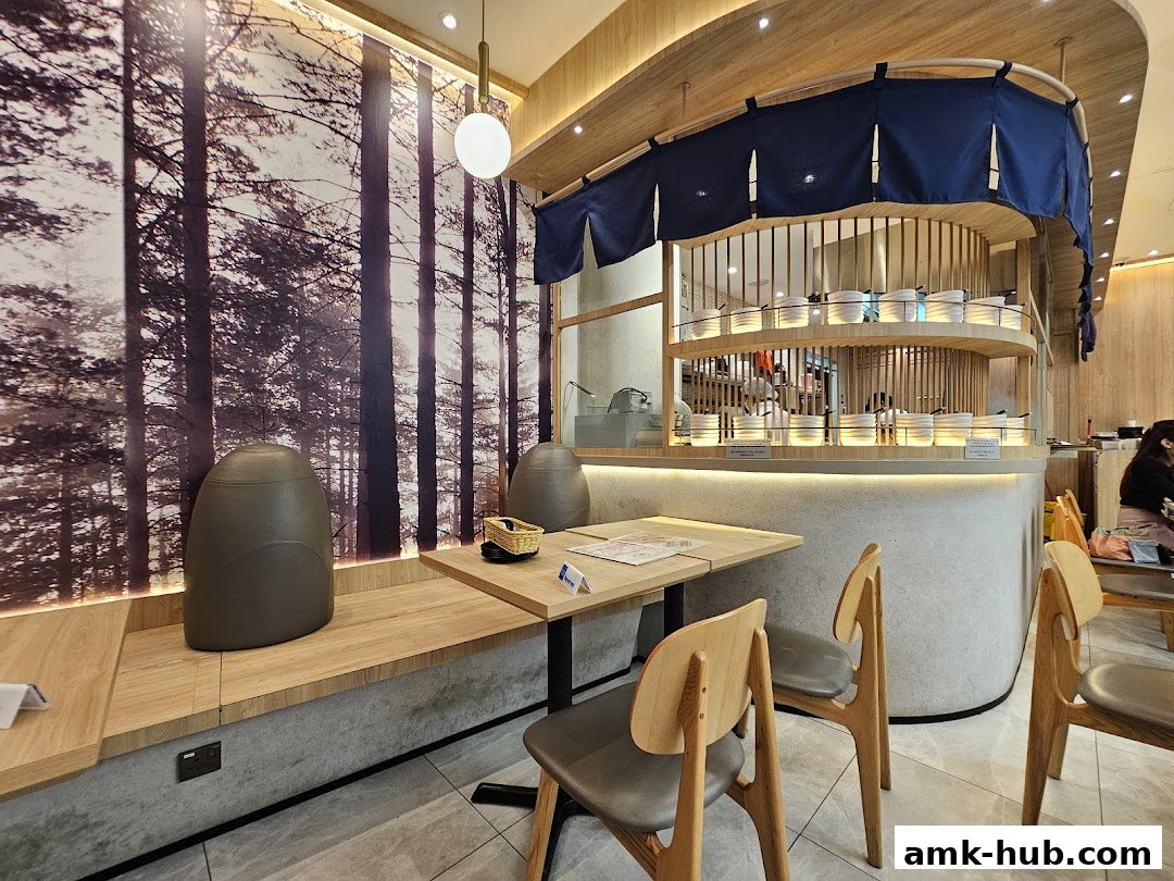 Interior of a modern restaurant with wooden accents and a forest-themed wallpaper.