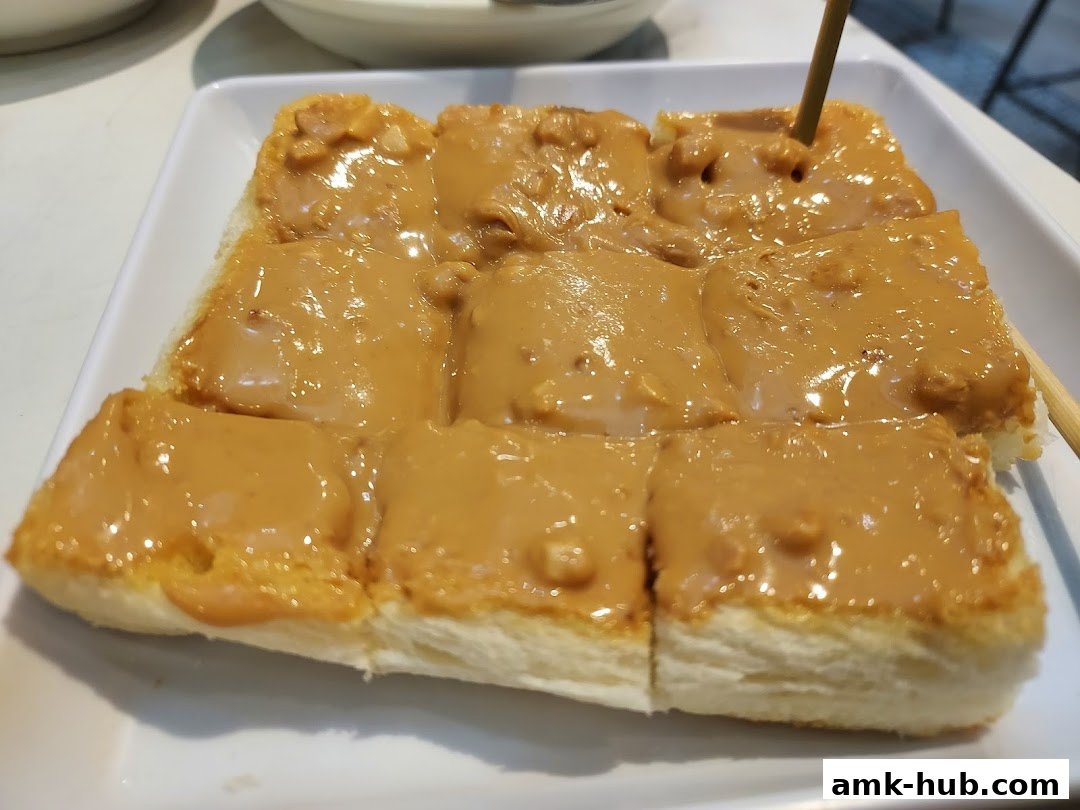 A close-up shot of peanut butter toast served on a white plate.