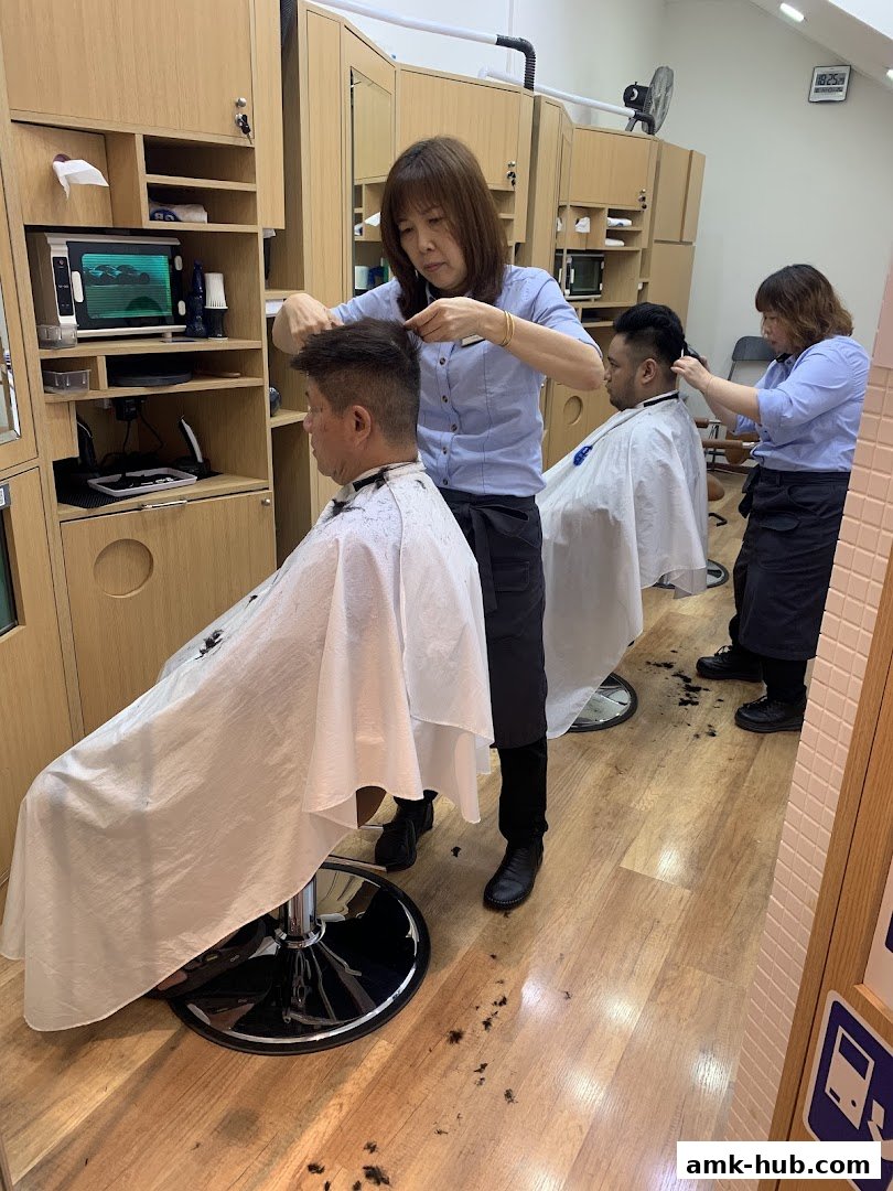 Two barbers are cutting hair for customers in a clean, modern salon.