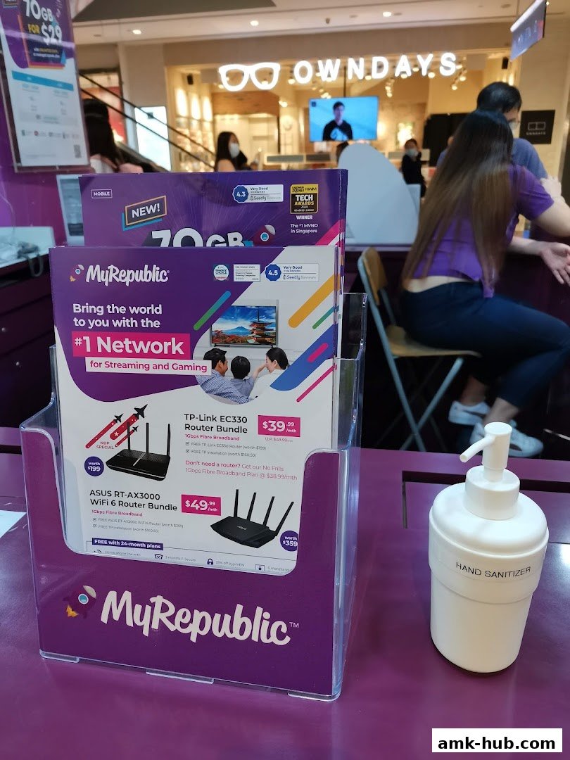 A display stand with brochures for MyRepublic's network and router bundles, alongside a hand sanitizer dispenser.