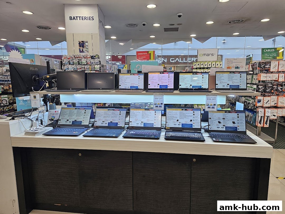 A display of various laptops and monitors in an electronics store.
