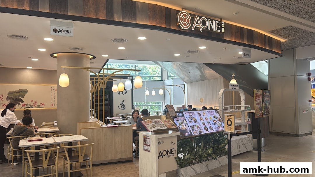 Interior view of A-One Signature restaurant with customers dining and menu displays.