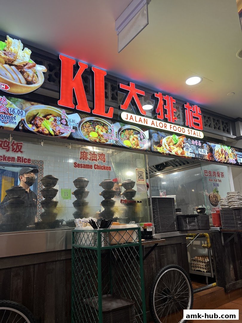 A food stall with a large illuminated sign and pictures of various dishes.