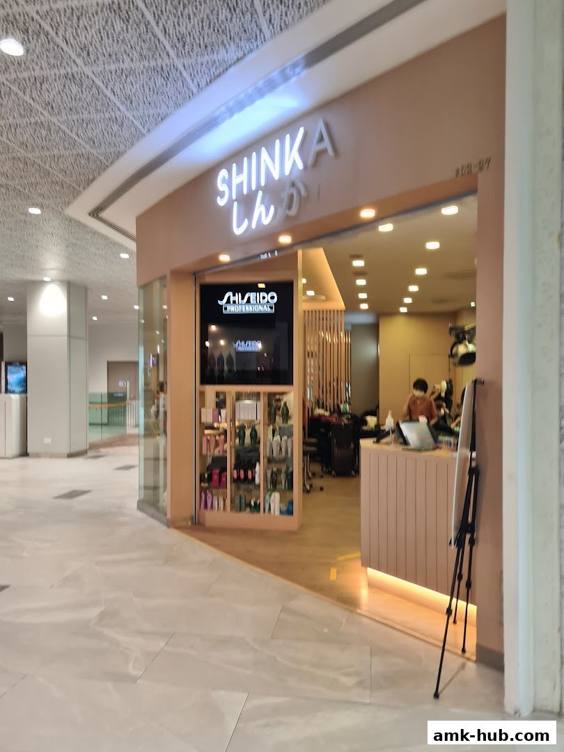 The entrance of the Shinka hair salon, featuring a prominent sign and display of hair products.