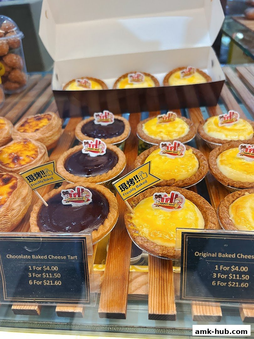 A display of freshly baked cheese tarts, including chocolate and original flavors, with pricing information.