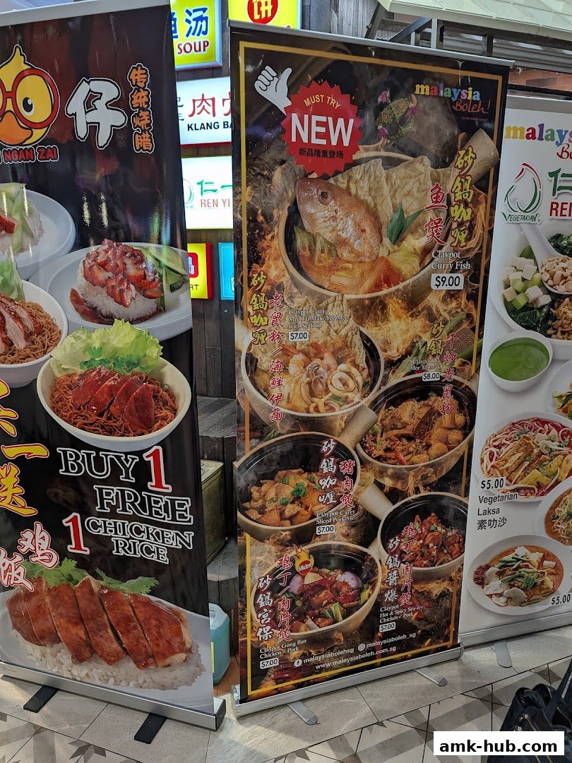 A display of promotional banners for Malaysian cuisine, featuring dishes like chicken rice and claypot meals.