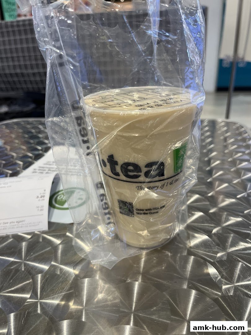 A cup of iTEA drink in a plastic bag on a metallic table.