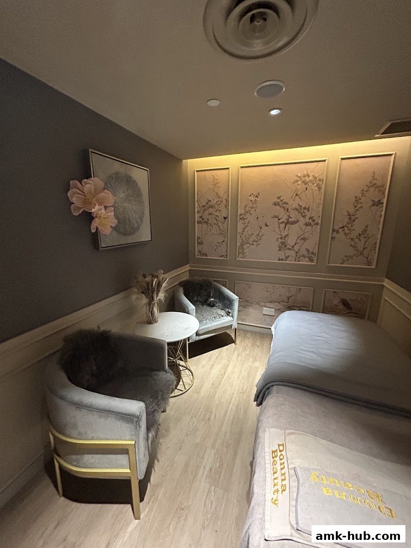 A serene treatment room at Donna Beauty with plush seating and a massage bed.