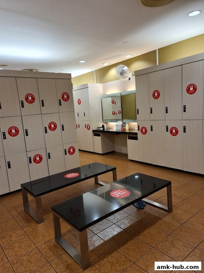 Locker room with benches, mirrors, and lockers with social distancing stickers.