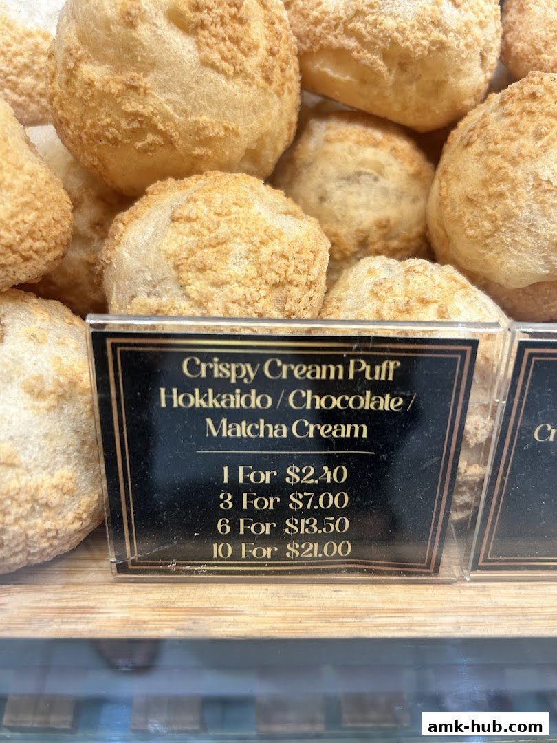 A close-up of crispy cream puffs with a price list for Hokkaido, Chocolate, and Matcha flavors.