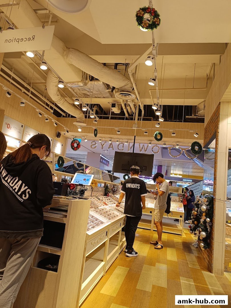 Interior view of an OWNDAYS optical shop with customers and staff.