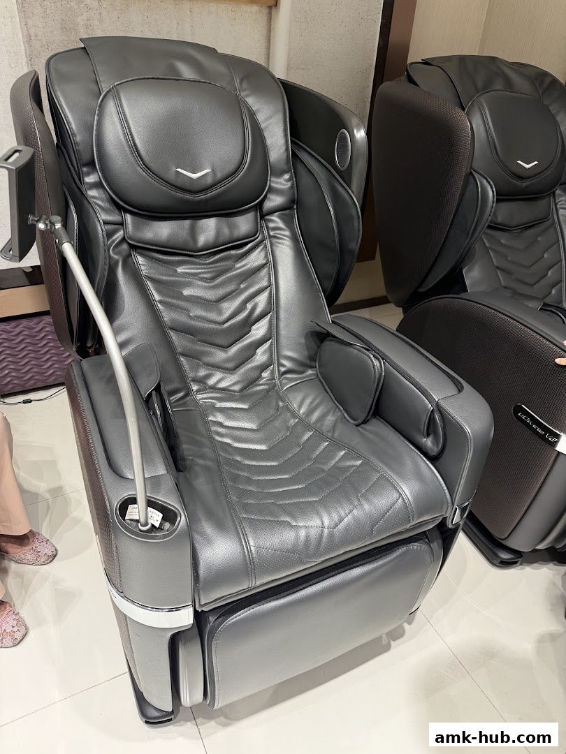 A close-up view of a luxurious black massage chair with intricate detailing.