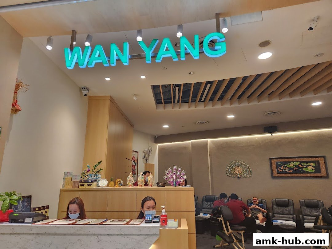 Interior of Wan Yang Health Product and Foot Reflexology Centre with staff at reception and customers receiving foot massages.
