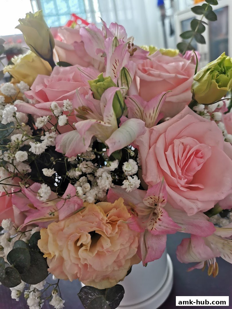 A close-up of a beautiful bouquet featuring pink roses, alstroemeria, and baby's breath.