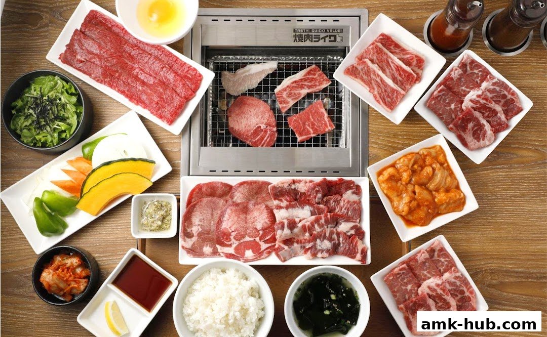 A spread of raw and grilling meats, vegetables, rice, and kimchi for a yakiniku meal.
