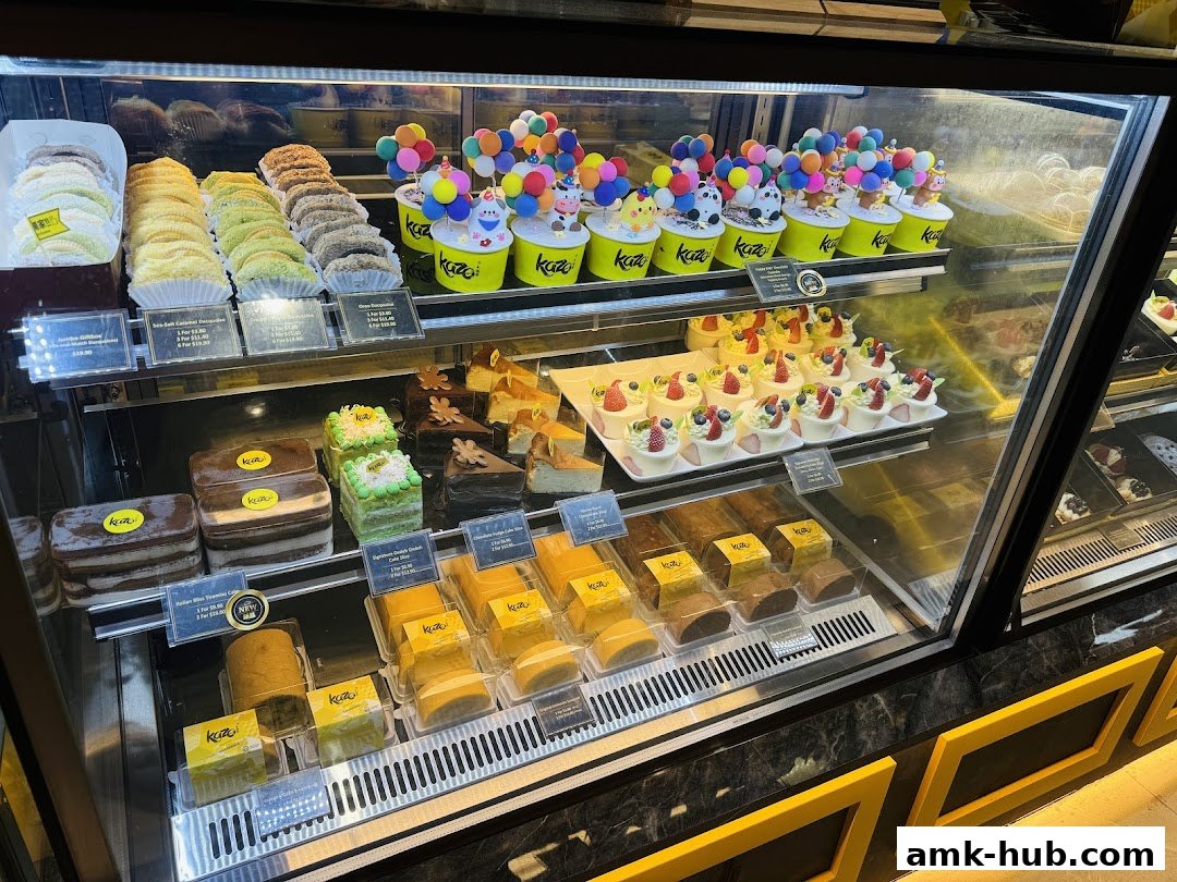 A display case filled with various cakes, pastries, and desserts, featuring colorful decorations.