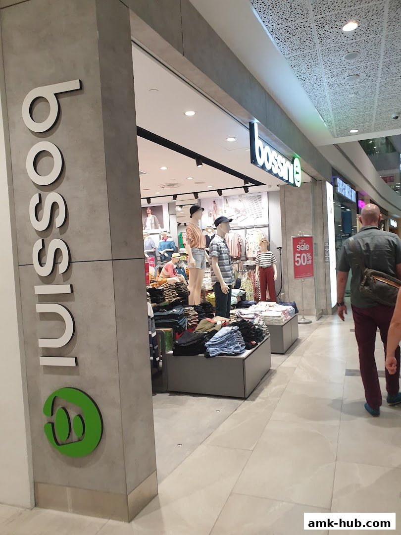 The exterior of a Bossini clothing store with mannequins displaying apparel and a sale sign.