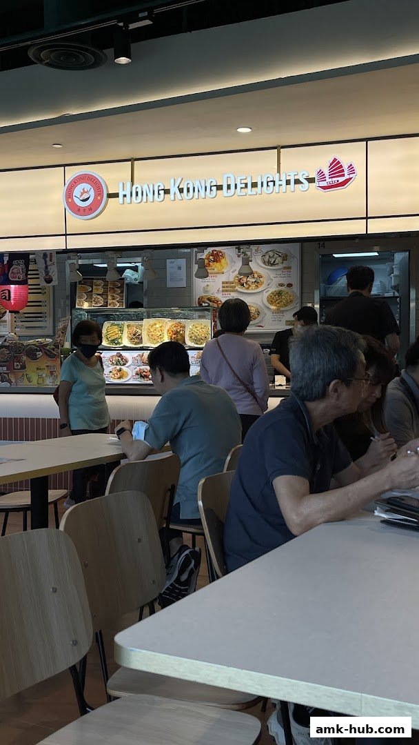 Customers dine at Hong Kong Delights, a food stall with a visible menu and food display.