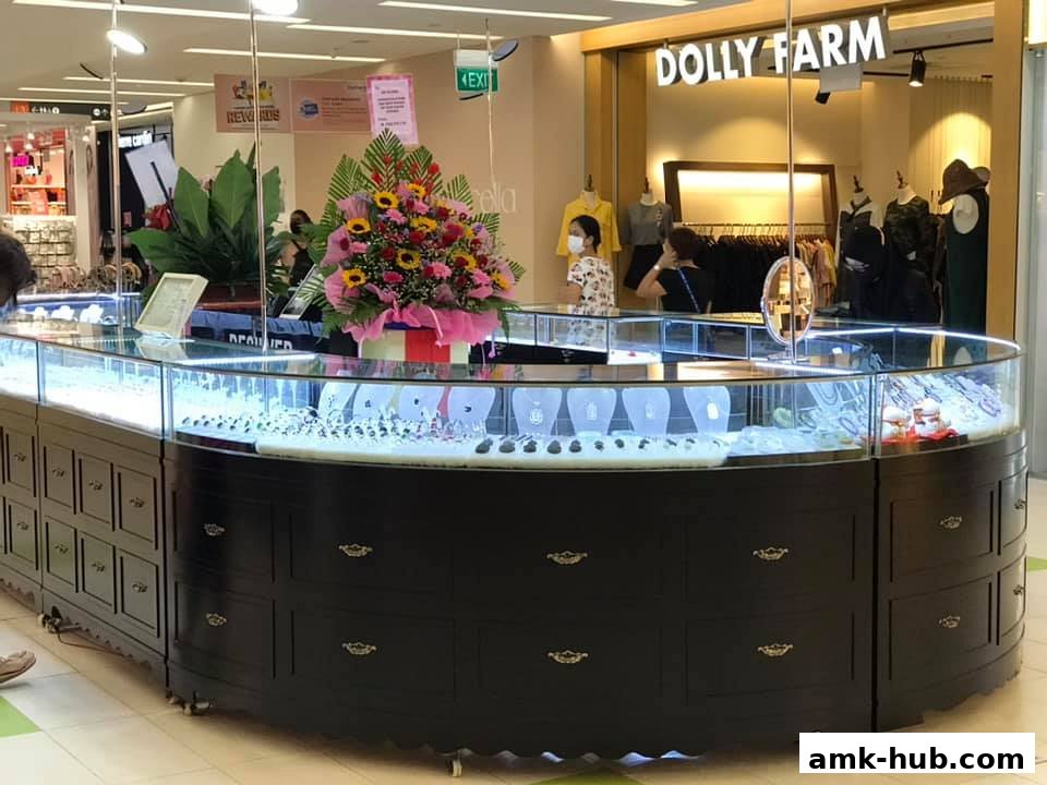 A jewelry display counter with various necklaces and rings, in front of a clothing store.