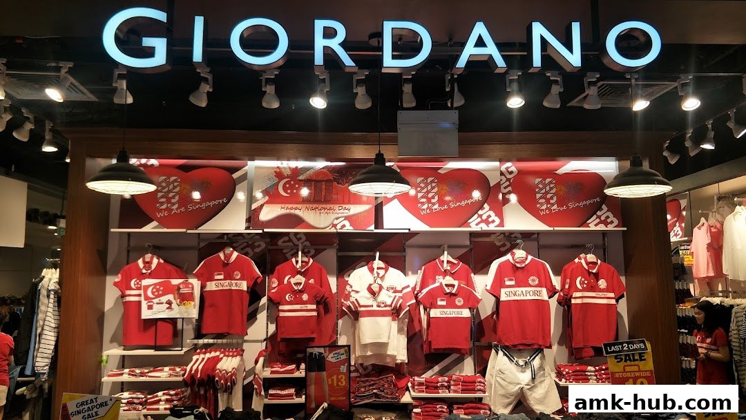 Giordano shop front displaying red and white apparel with Singapore-themed graphics and sale signs.