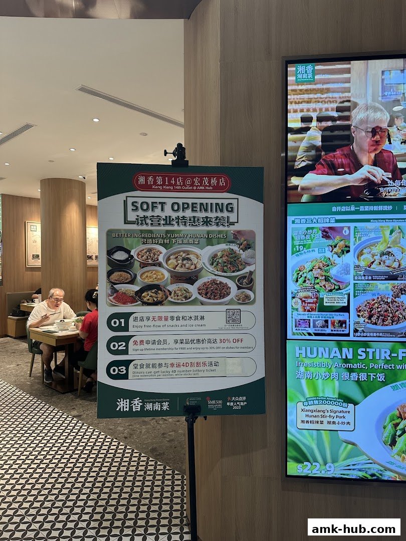 A sign advertises the soft opening of Xiang Xiang Hunan Cuisine with various promotions.