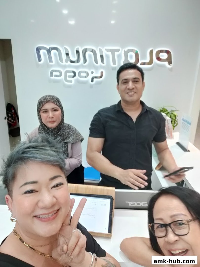 Four people smiling at the camera in front of a Platinum Yoga sign.