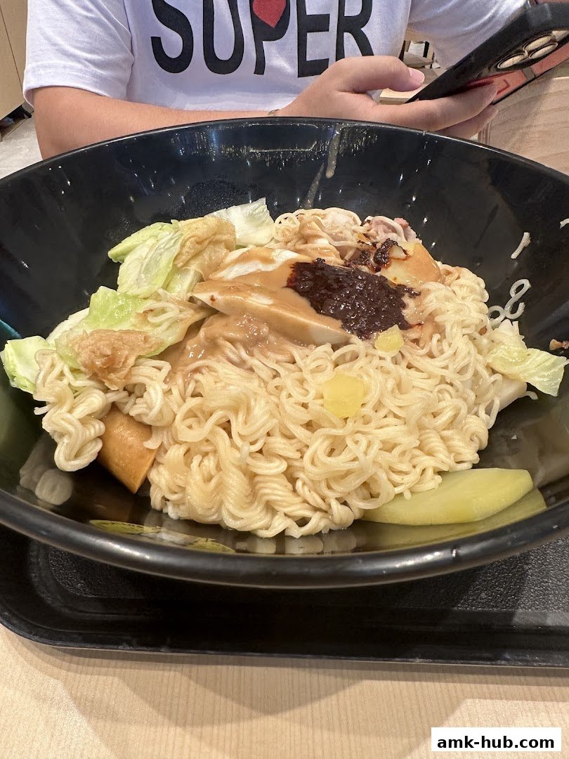A close-up of a bowl of Mala Tang with noodles, vegetables, and sausage.