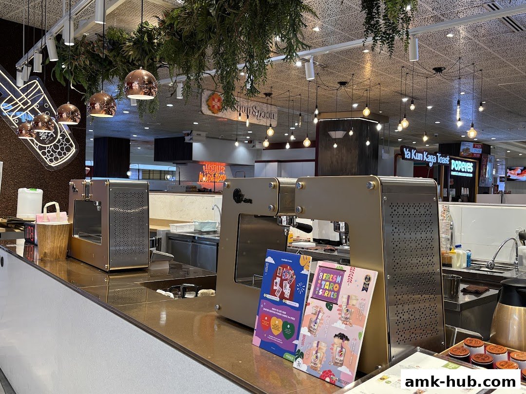 Interior shot of a bubble tea shop counter with brewing equipment and promotional flyers.