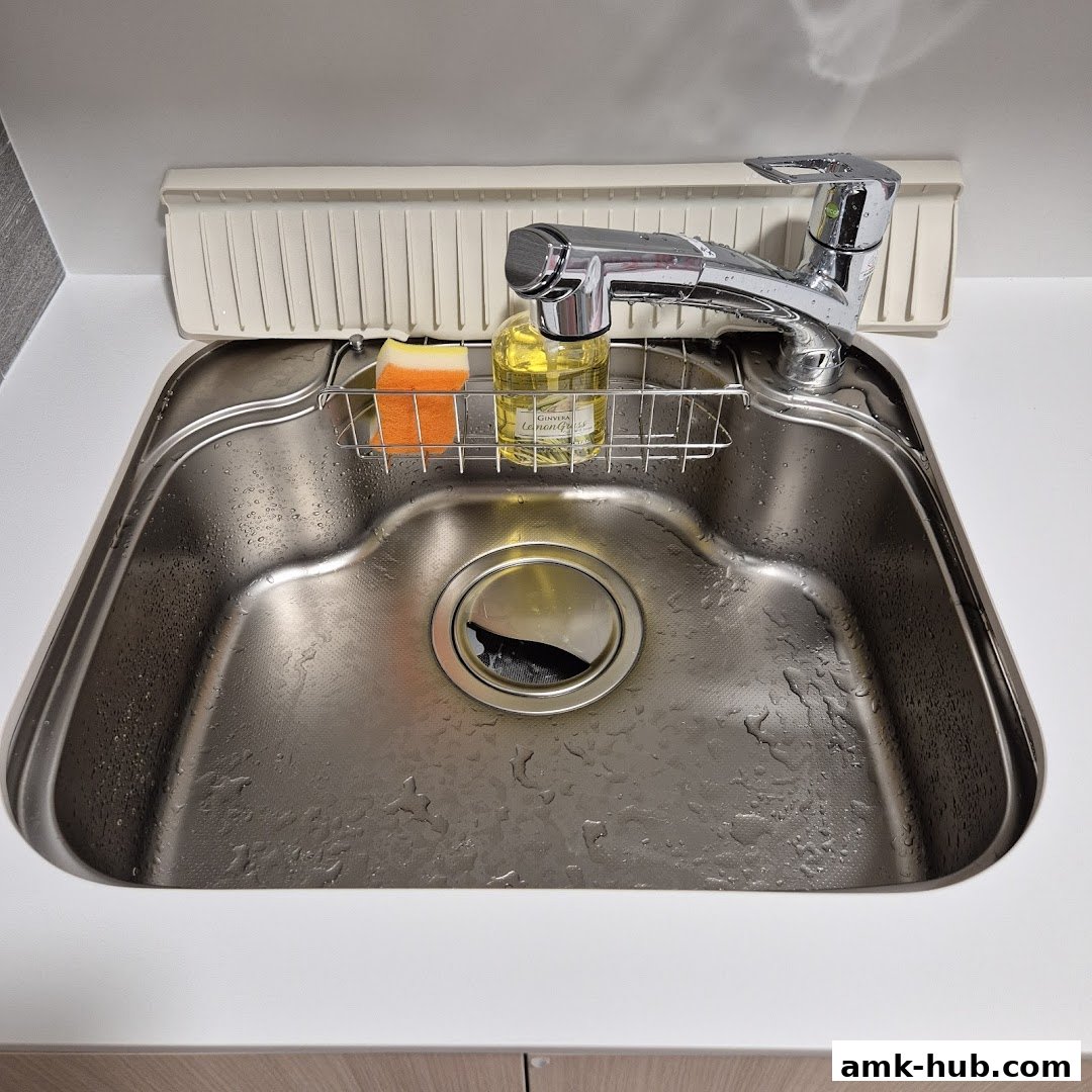 A clean kitchen sink with a faucet, sponge, and dish soap.