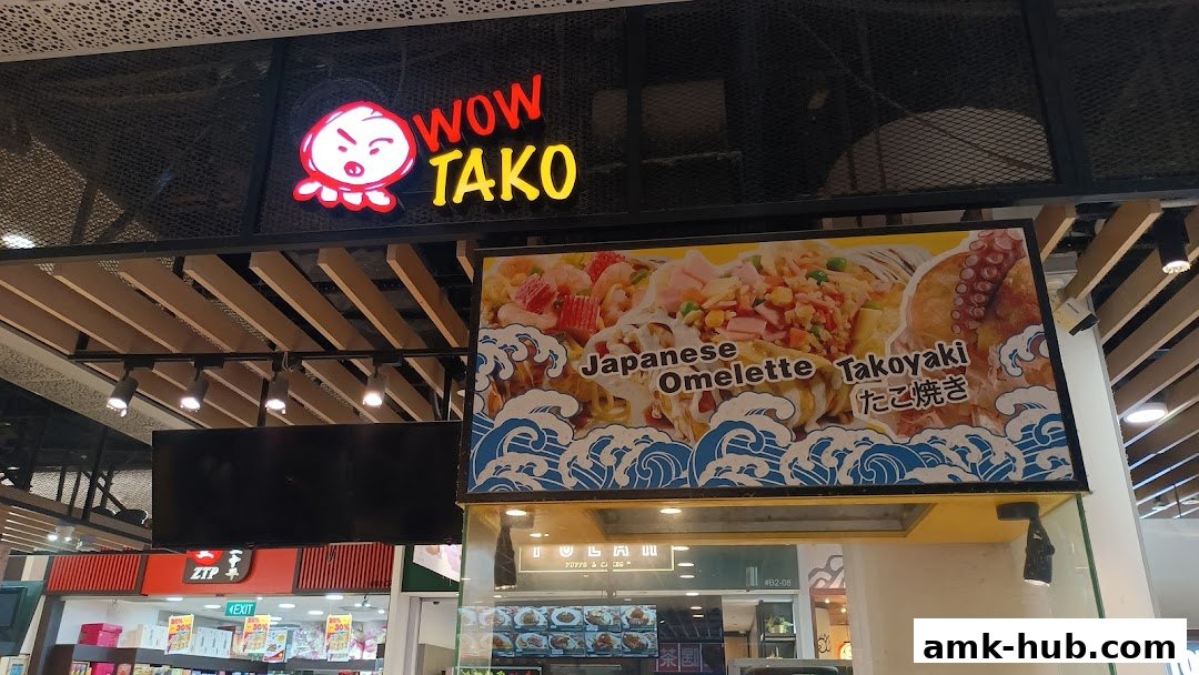 The Wow Tako shop front features a vibrant sign and a large display showcasing Japanese Omelette and Takoyaki.
