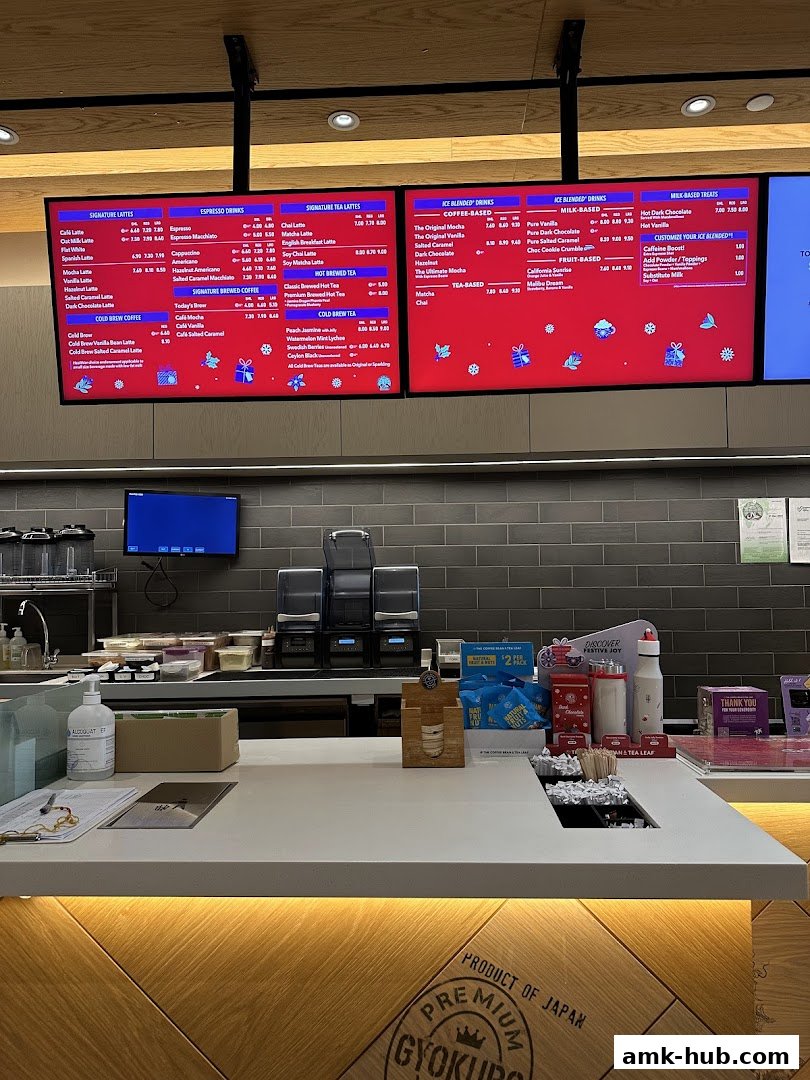 A digital menu board displaying various coffee and tea drinks with prices.