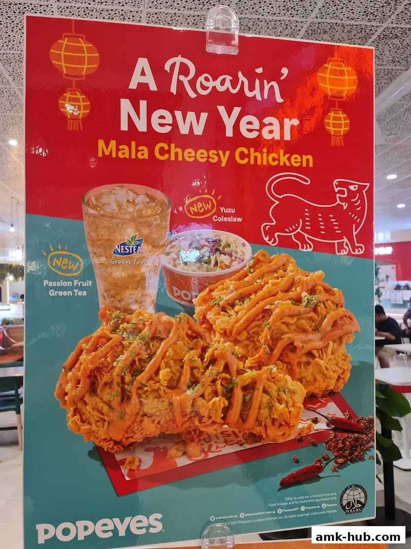 A Popeyes promotional poster featuring Mala Cheesy Chicken, Yuzu Coleslaw, and Passion Fruit Green Tea.