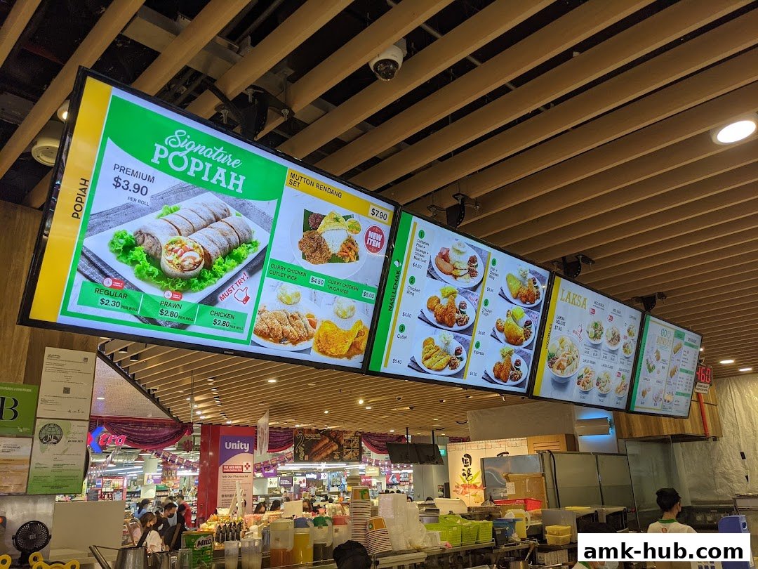 Digital menu boards displaying various food items and prices at Qi Ji.