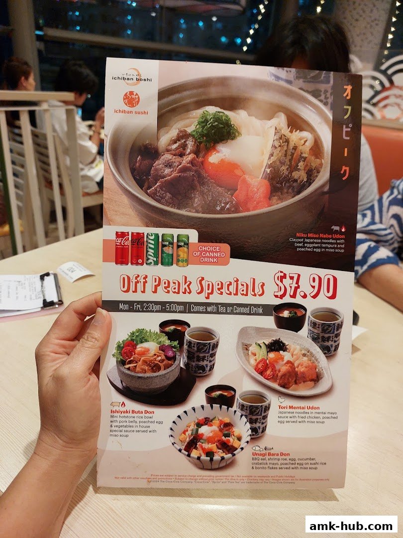 A person holds a menu from Ichiban Sushi featuring off-peak specials and various Japanese dishes.
