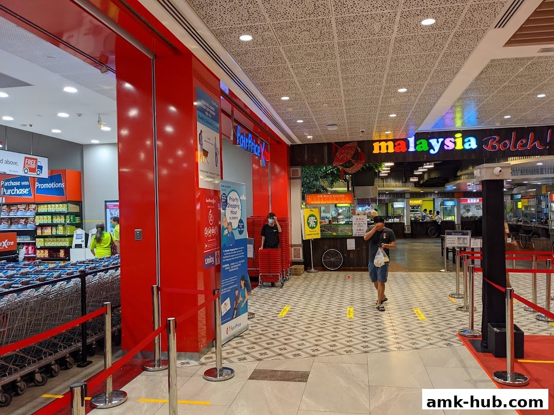 The entrance to FairPrice Xtra supermarket with trolleys and promotional signage.