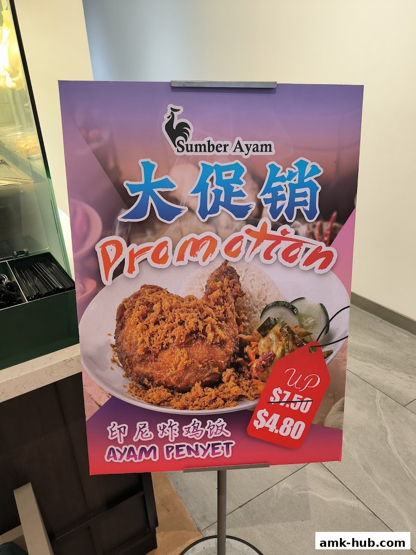 A promotional sign for Sumber Ayam featuring Ayam Penyet with a discounted price.