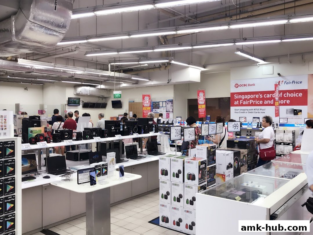Interior of a FairPrice supermarket with electronics and a checkout counter.