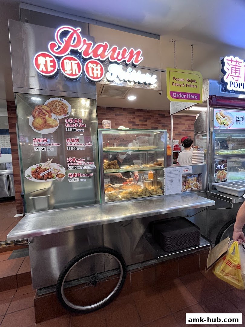 A food stall selling various Malaysian snacks like fritters, satay, and popiah.